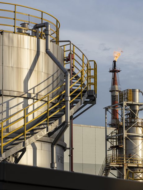 Planta de óleo e gás com tanques e tubulação ao entardecer