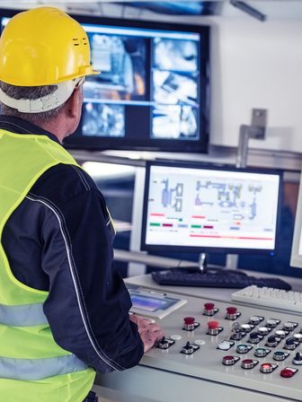 Operador em sala de controle acompanhando o supervisório