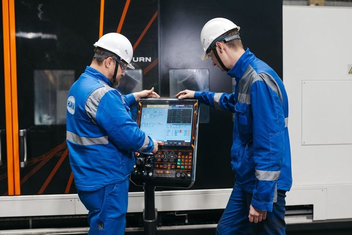 Dois engenheiros operando a IHM de uma máquina